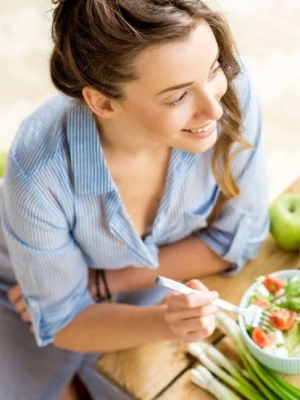 Frau isst einen frischen Salat, Ern&auml;hrung ist ein Thema der Ausbildung
